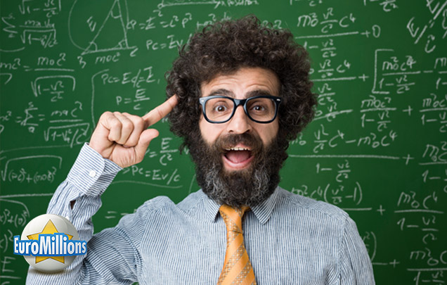 Mann mit Bart und Brille steht vor einer Tafel, die mit mathematischen Formeln beschrieben ist